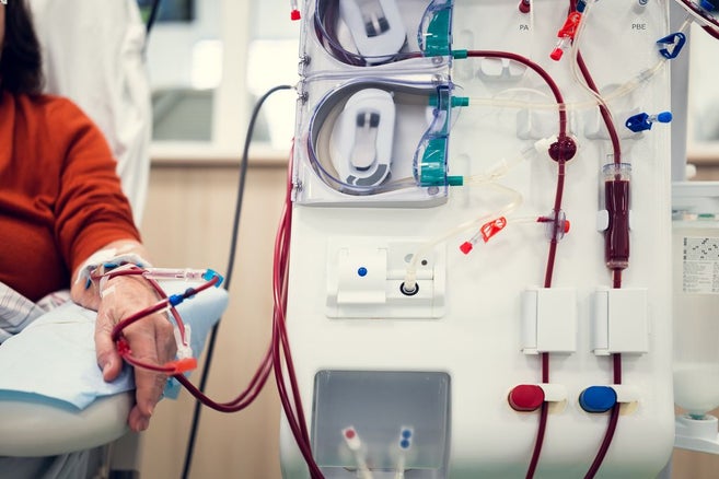 žena středního věku má ruku položenou v blízkosti zdravotnického prostředku a dostává léky několika katétry