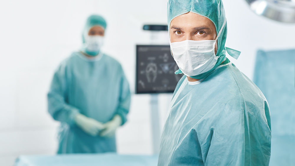 Dva chirurgové s OrthoPilot® Elite v pozadí