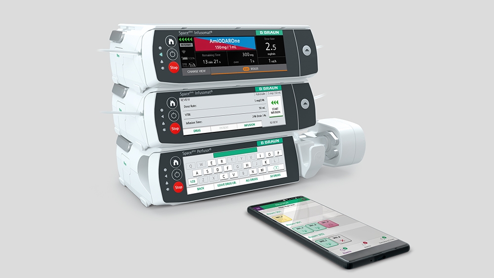 Infuzní systém Space Plus, před ním leží chytrý telefon s otevřenou příslušnou aplikací. 
