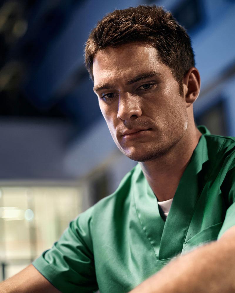 Vyčerpaná sestra sedící před nemocnicí