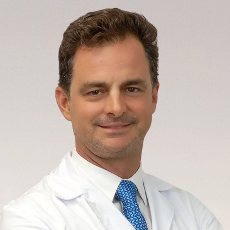 Portrét profesora Javiera Lópeze Monclúse v doktorském kabátě, který se sebevědomě usmívá do kamery