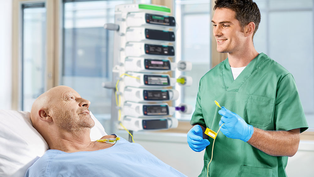 zdravotní sestra hovoří s pacientem u lůžka